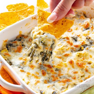 Spinach artichoke dip scooped with a chip.