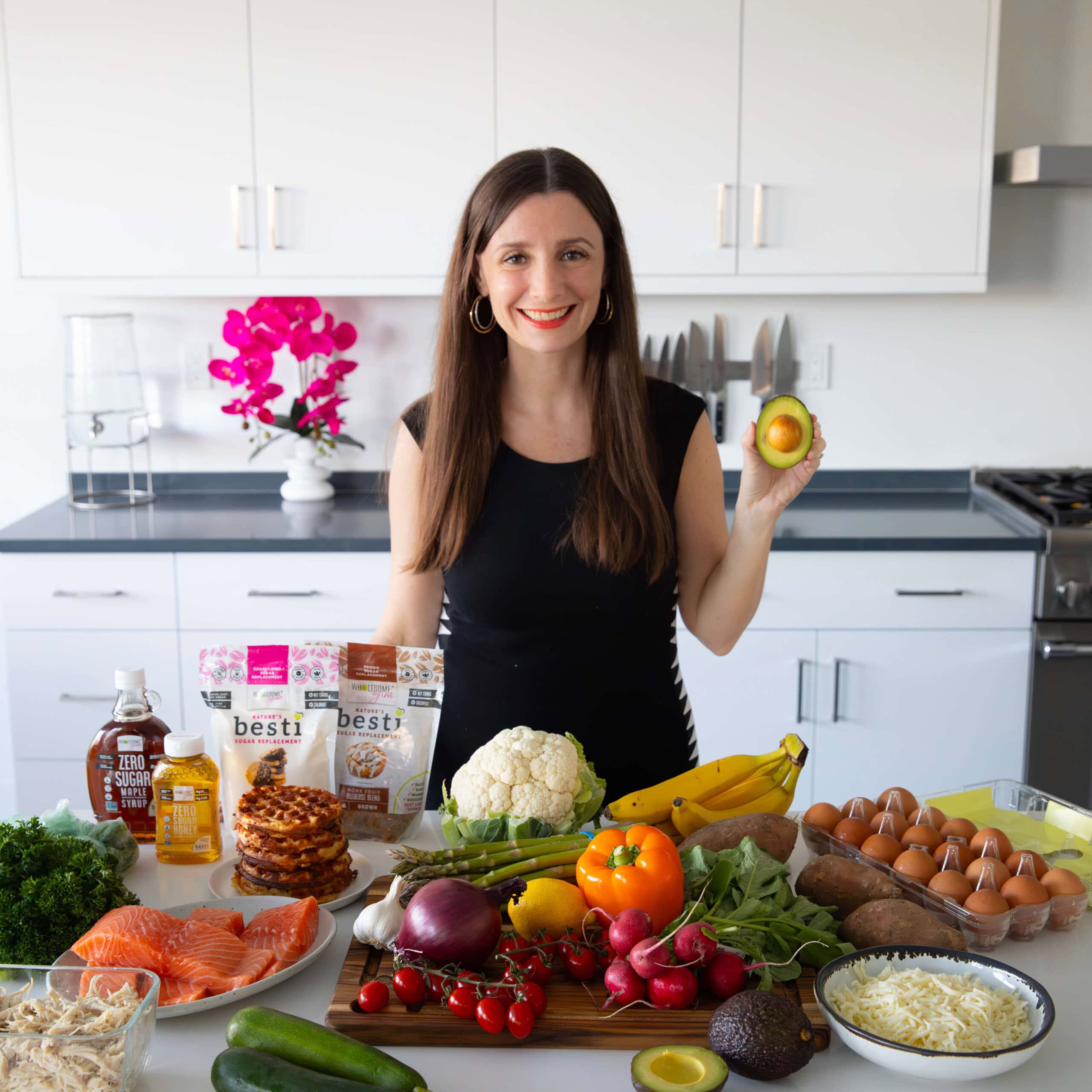 Maya holding an avocado with healthy ingredients.