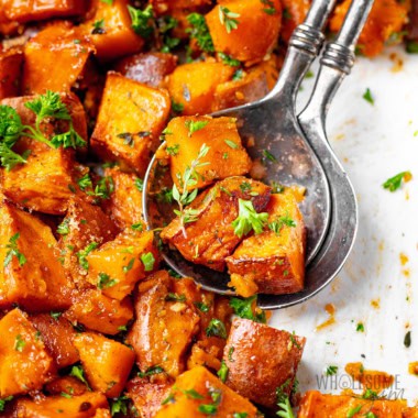 Roasted sweet potatoes up close with serving spoons.